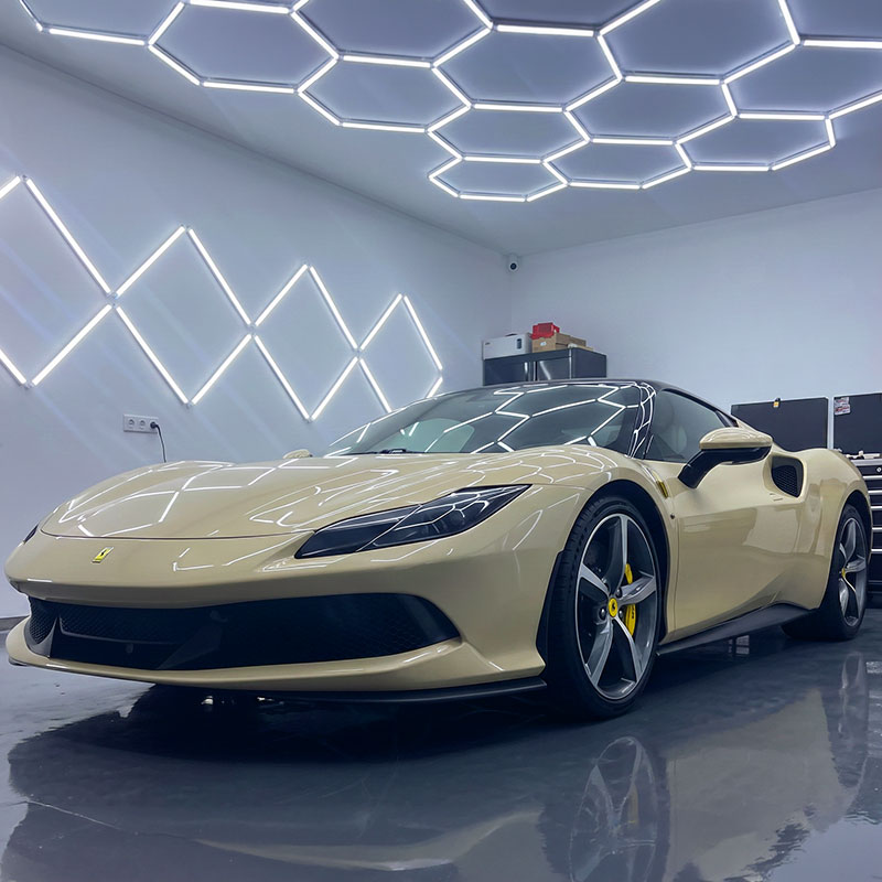 Gold sports car in a showroom with hexagon lights